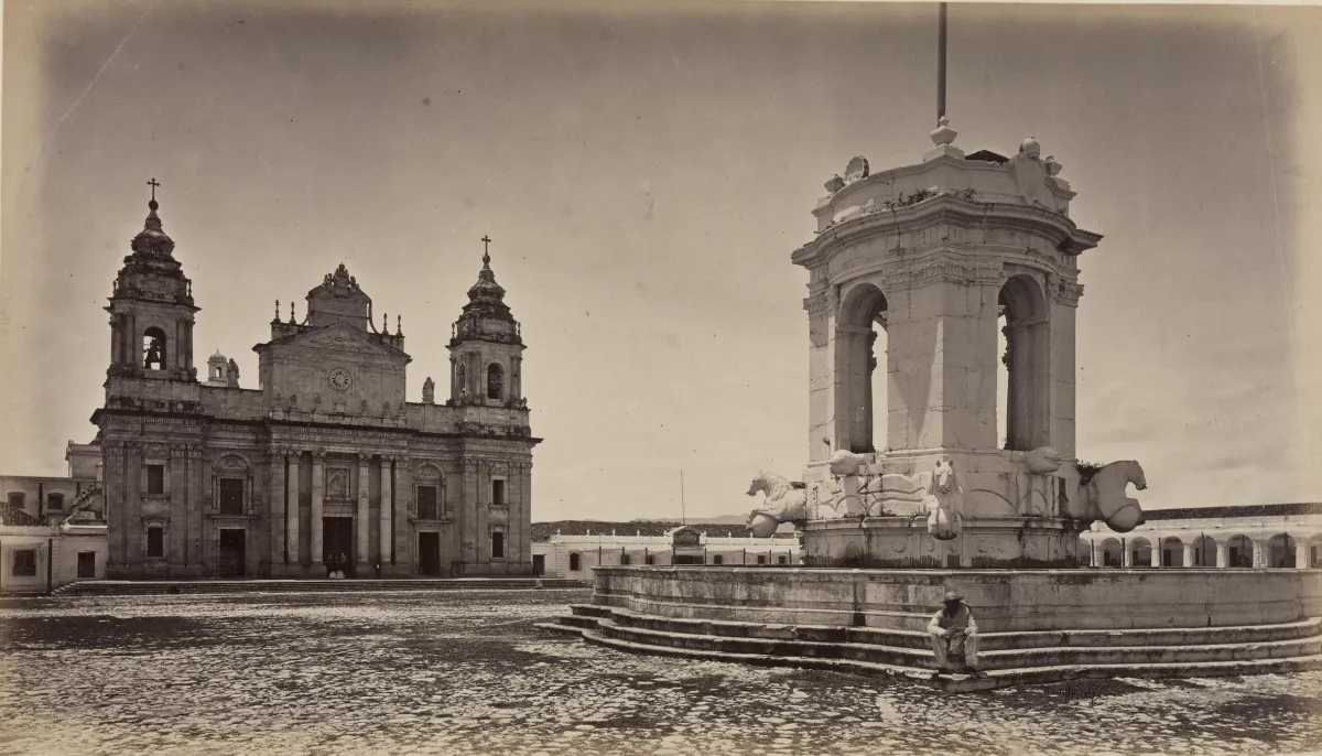La Plaza de Armas de la Ciudad de Guatemala en 1875: la Catedral con sus dos torres a la izquierda, una fuente grande de piedra a la derecha y la plaza casi vacía.